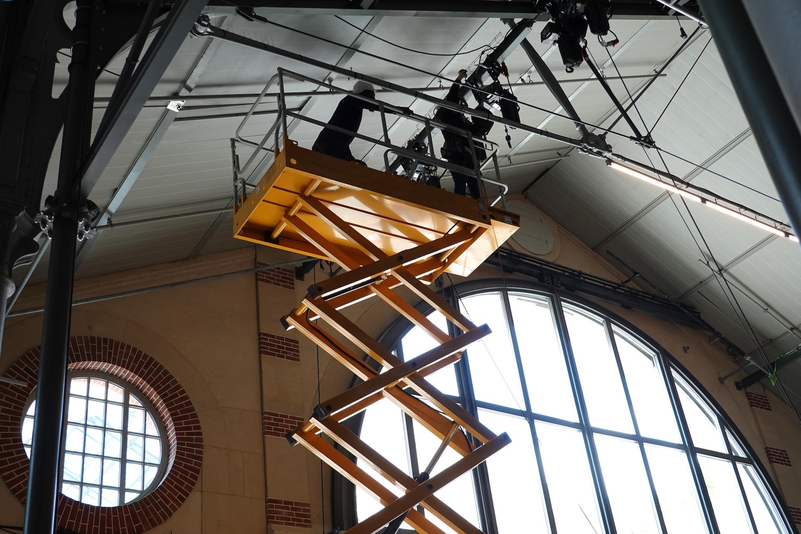 Workers on a scissor lift install lights