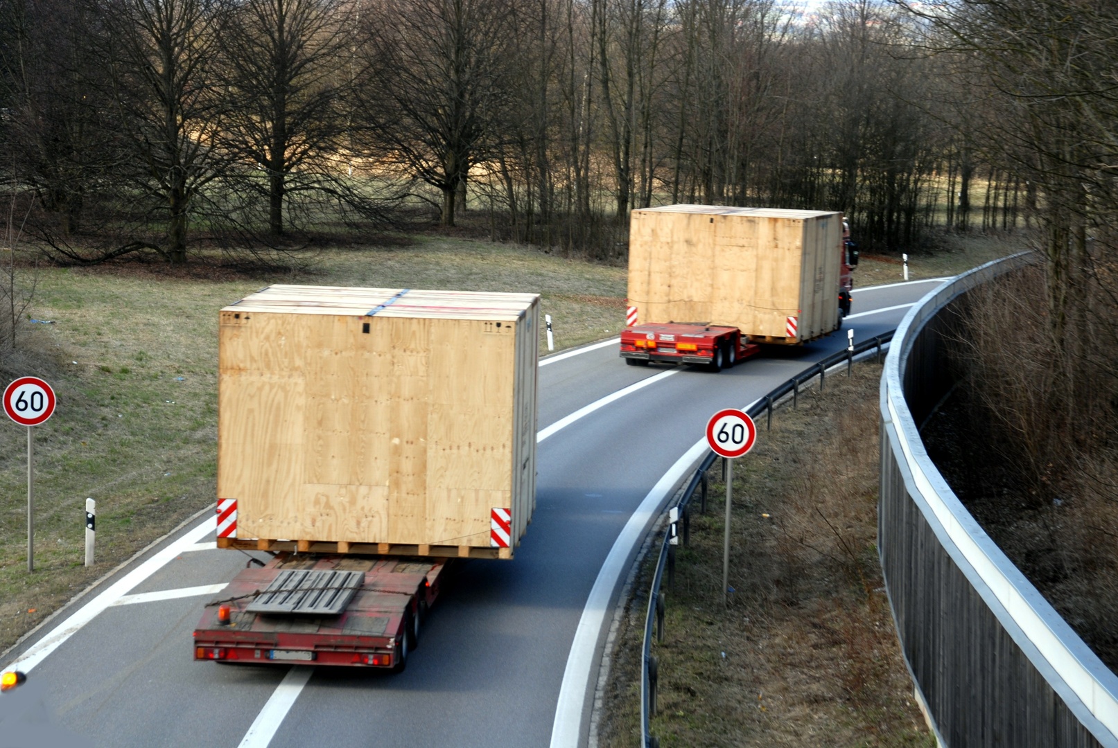 Schwertransport durch zwei LKW von hölzernen Containern 