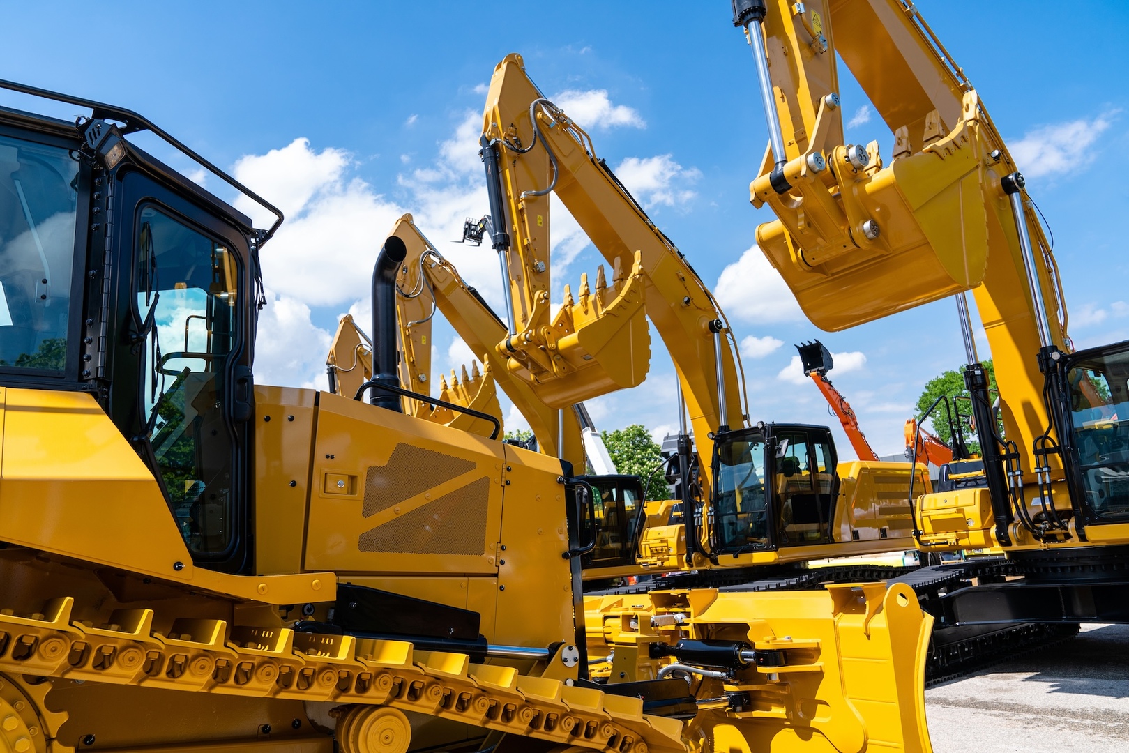 View of several yellow construction machines - excavator, crawler excavator