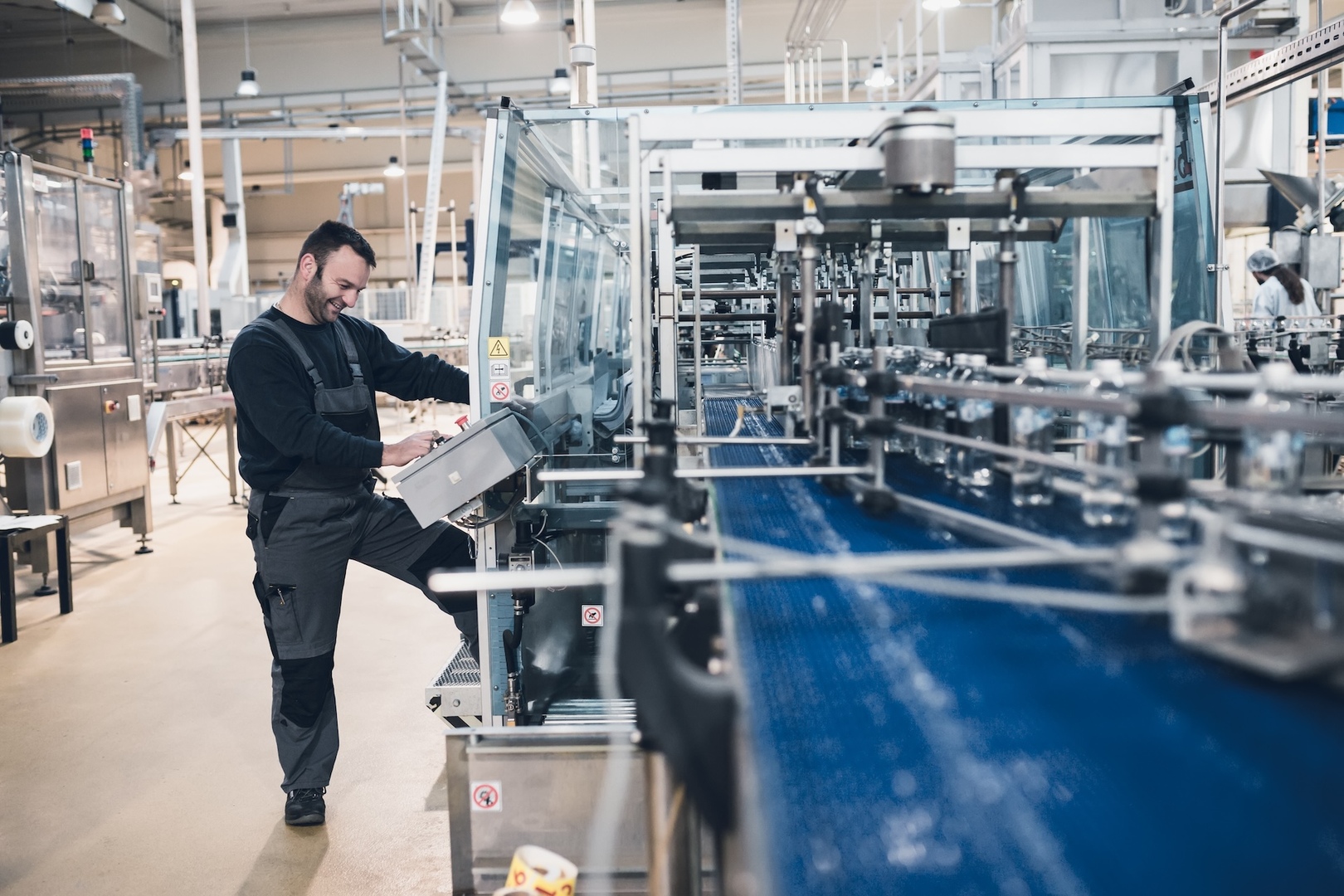 Employee at the control panel of a robot production line